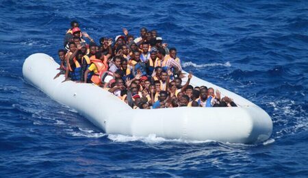 Inflatable_boat_carrying_migrants_approaching_USS_Carney_DDG-64_in_the_Mediterranean_160729-N-EU999-004-scaled-e1725435342464.jpg