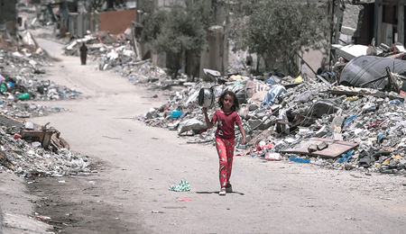 A_girl_walks_inside_Gaza_during_the_Gaza-Israel_war_to_get_food.png